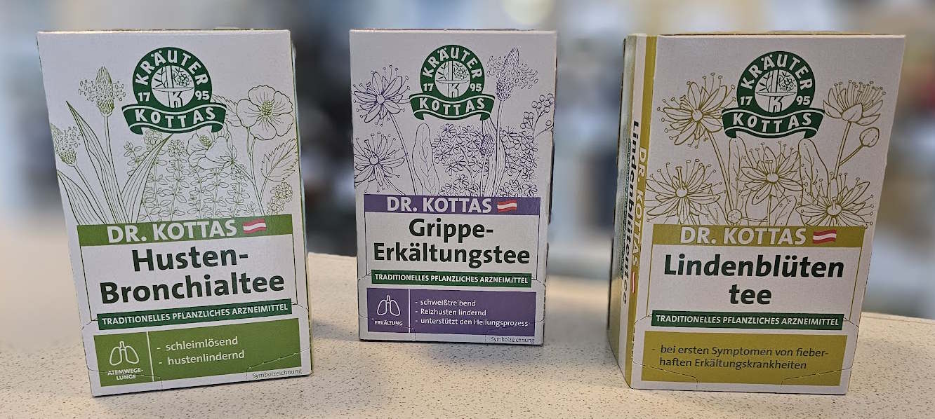 Abbildung zeigt bunte Faltschachteln von verschiedenen Tees: Grippe-Erkältungstee, Husten-Bronchialtee, Lindenblütentee in der Apotheke Ebenfurth